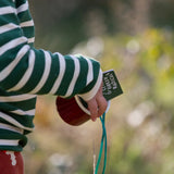 Close up of a child wearing the Little Green Radicals olive green striped long sleeve top