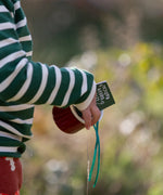 Close up of a child wearing the Little Green Radicals olive green striped long sleeve top