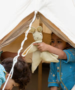 A child holding the Little Green Radicals rabbit organic cotton baby comforter toy up. 