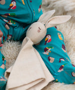 A close up of the Little Green Radicals rabbit organic cotton baby comforter toy on a baby's lap.