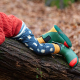 Child wearing Little Green Radicals organic cotton comfy joggers with a blue penguins design and green wellington boots.
