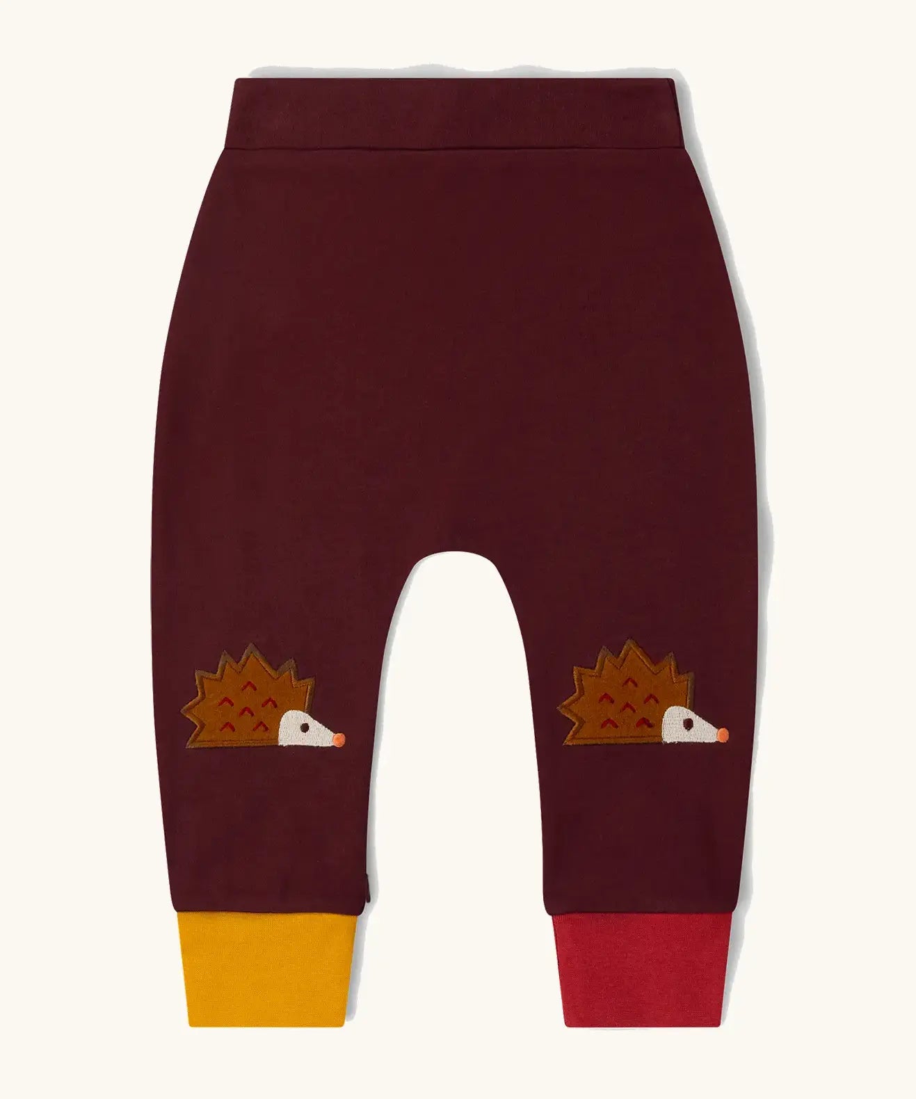 Little Green Radicals organic cotton hedgehogs knee patch joggers with one yellow and one red leg cuffs.
