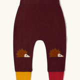 Little Green Radicals organic cotton hedgehogs knee patch joggers with one yellow and one red leg cuffs.