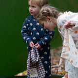 A child wearing the Little Green Radicals  Organic Cotton Sleeping Sheep print Pyjamas. Another child is standing besides them. Little green Radicals have a wide range of organic cotton, Fairtrade children's clothing an outerwear available here at Babipur.