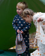 A child wearing the Little Green Radicals  Organic Cotton Sleeping Sheep print Pyjamas. Another child is standing besides them. Little green Radicals have a wide range of organic cotton, Fairtrade children's clothing an outerwear available here at Babipur.