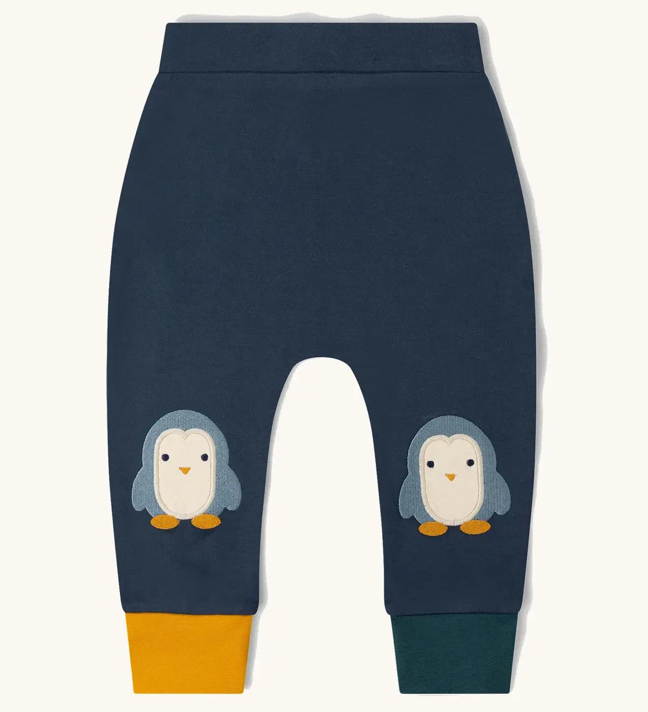 Little Green Radicals organic cotton penguin knee patch joggers with one yellow and one dark green leg cuff.