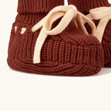 Close up of the Little Green Radicals hazelnut rust brown organic cotton knitted baby booties.