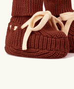 Close up of the Little Green Radicals hazelnut rust brown organic cotton knitted baby booties.