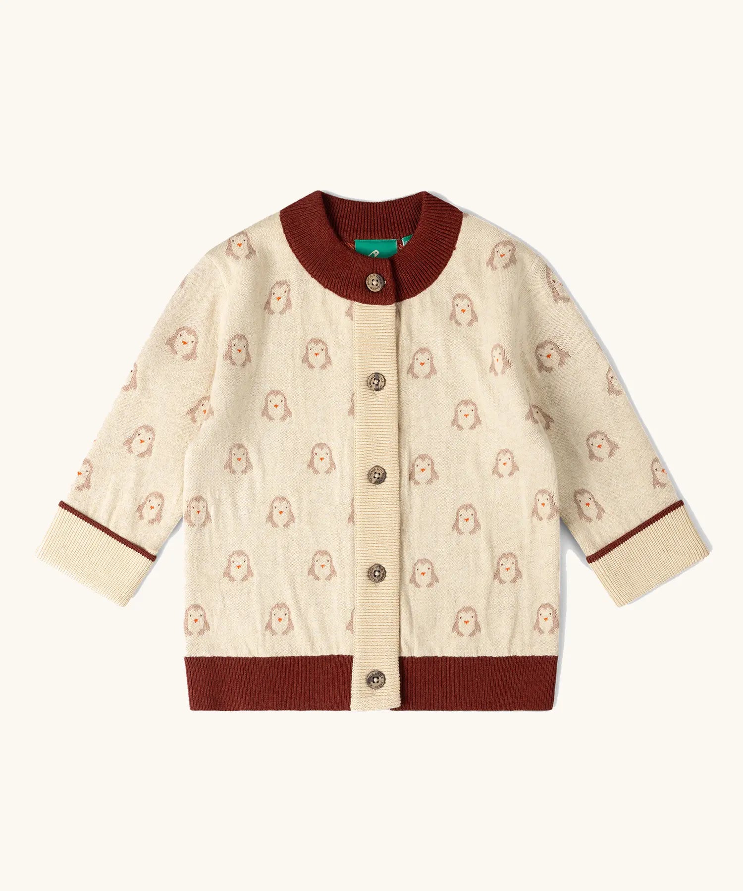 Little Green Radicals organic cotton knitted cardigan with snow penguins design. Natural cream cardigan with penguins all over, maroon trim on the collar and hem line.