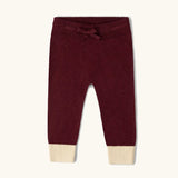 Little Green Radicals organic cotton knitted joggers in a winter berry colour.