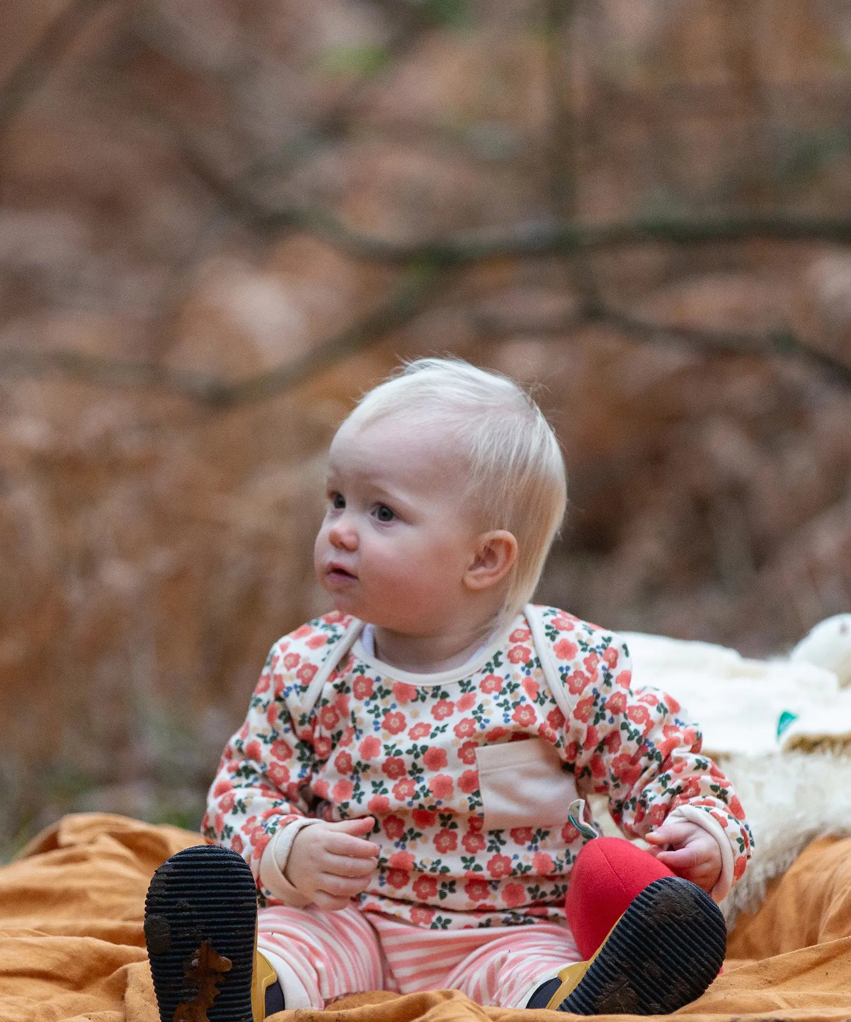 Baby wearing the Little Green Radicals organic cotton long sleeve top and jogger playset with pink petals flowers design.