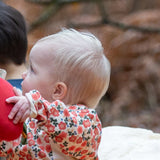 Baby wearing the Little Green Radicals organic cotton long sleeve top and jogger playset with pink petals flowers design.