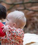 Baby wearing the Little Green Radicals organic cotton long sleeve top and jogger playset with pink petals flowers design.