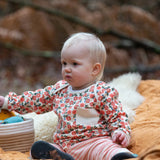 Baby wearing the Little Green Radicals organic cotton long sleeve top and jogger playset with pink petals flowers design.