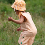  Little Green Radicals organic cotton reversible Flora sunhat with a yellow and white gingham design on a child. View of back.