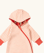Close up of the top of the Little Green Radicals pink unicorns organic cotton reversible snug suit. One side is pink with a repeat unicorns print, the other is light pink and white striped. 