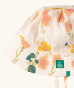 Close up of the Little Green Radicals organic cotton reversible Flora sunhat showing the repeat pink and yellow flower print .