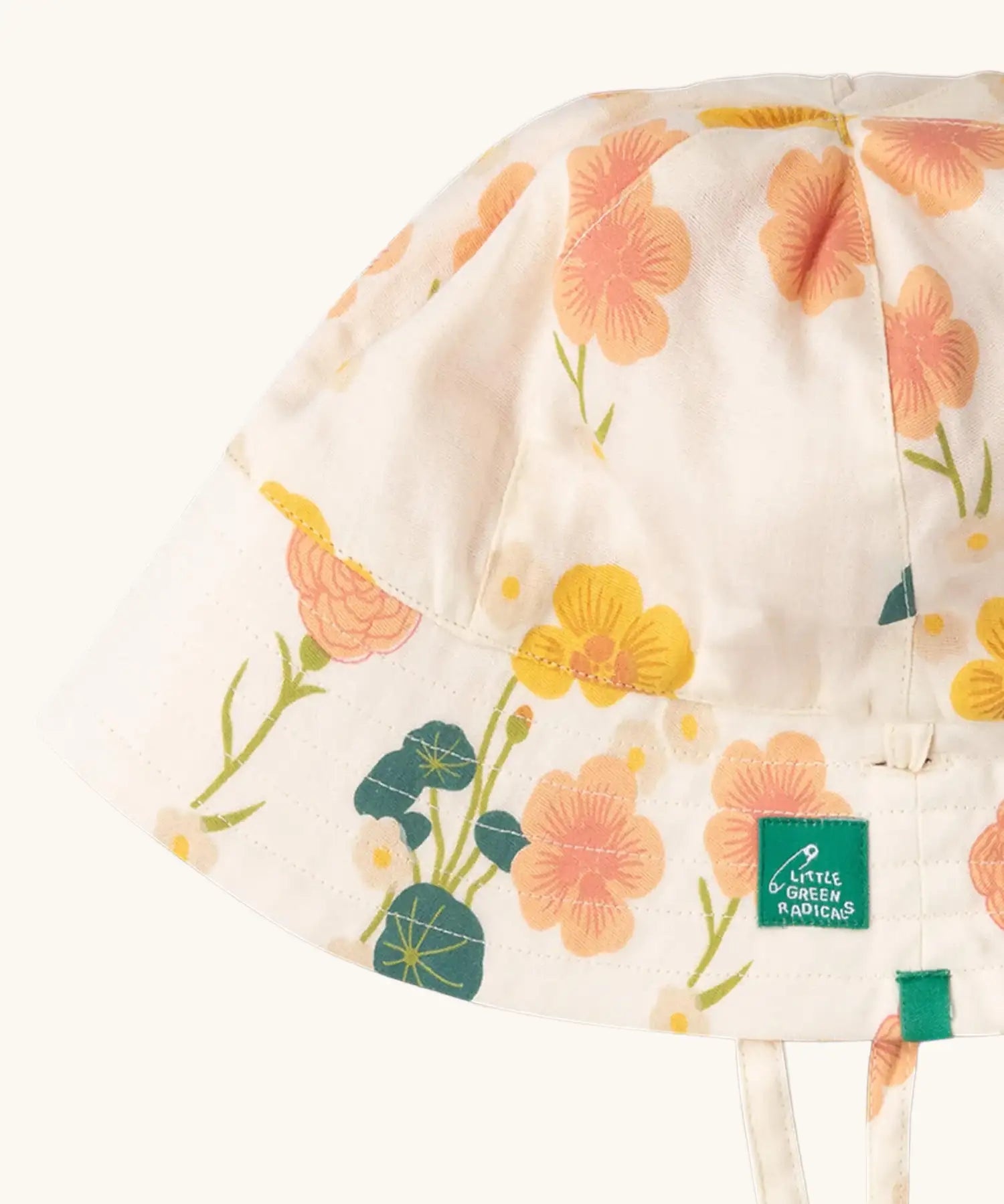Close up of the Little Green Radicals organic cotton reversible Flora sunhat showing the repeat pink and yellow flower print .