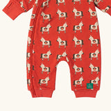 Close up of the front of the Little Green Radicals pink unicorns organic cotton reversible snug suit. One side is pink with a repeat unicorns print, the other is light pink and white striped. 