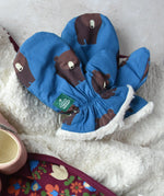 Little Green Radicals Organic Cotton Sherpa-Lined Children's bear print mittens placed on a sherpa lined blanket.