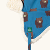 Close up of the Little Green Radicals organic cotton sherpa-lined trapper hat in blue with a bears print.