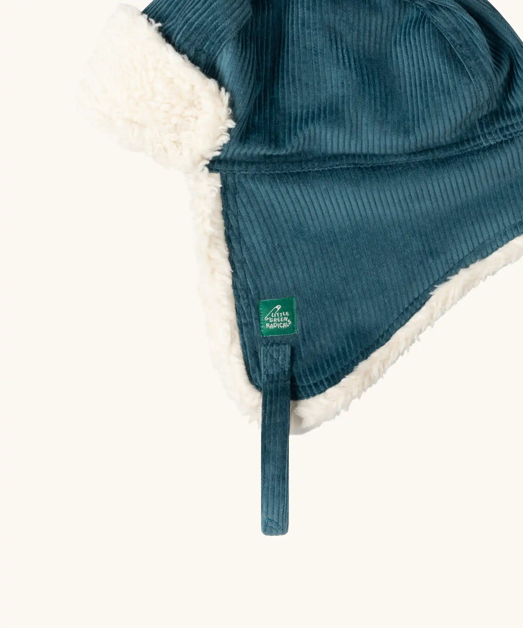 Close up of the Little Green Radicals organic cotton sherpa-lined trapper hat in blue.