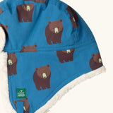 Close up of the Little Green Radicals organic cotton sherpa-lined trapper hat in blue with a bears print.