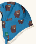 Close up of the Little Green Radicals organic cotton sherpa-lined trapper hat in blue with a bears print.