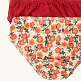 Close up of the elasticated leg hems on the Little Green Radicals organic cotton underwear in a 3 pack. Brief style pants one with a petals print, one red, one pink and white stripes. 