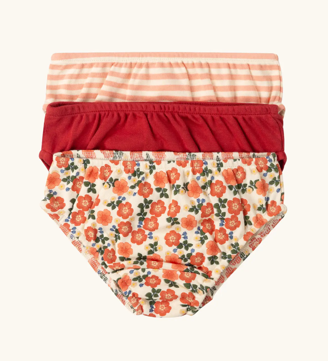 Little Green Radicals organic cotton underwear in a 3 pack. Brief style pants one with a petals print, one red, one pink and white stripes. 