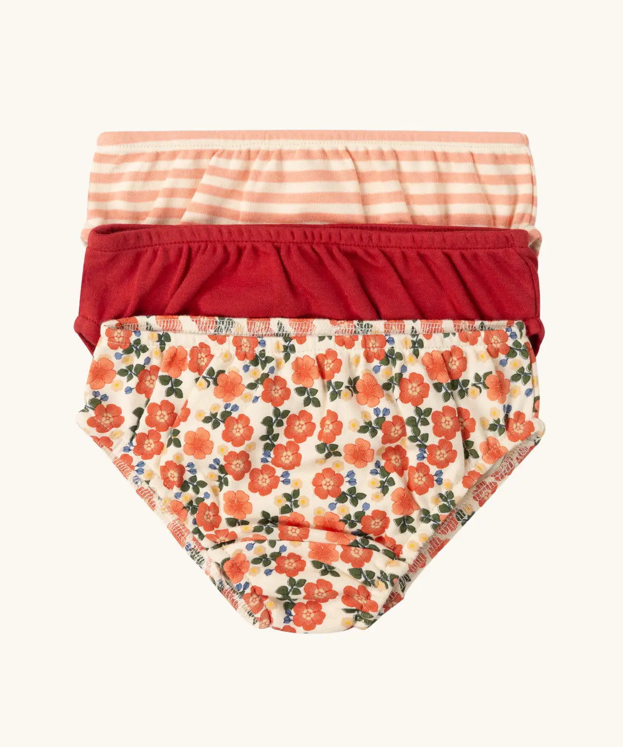 Little Green Radicals organic cotton underwear in a 3 pack. Brief style pants one with a petals print, one red, one pink and white stripes. 