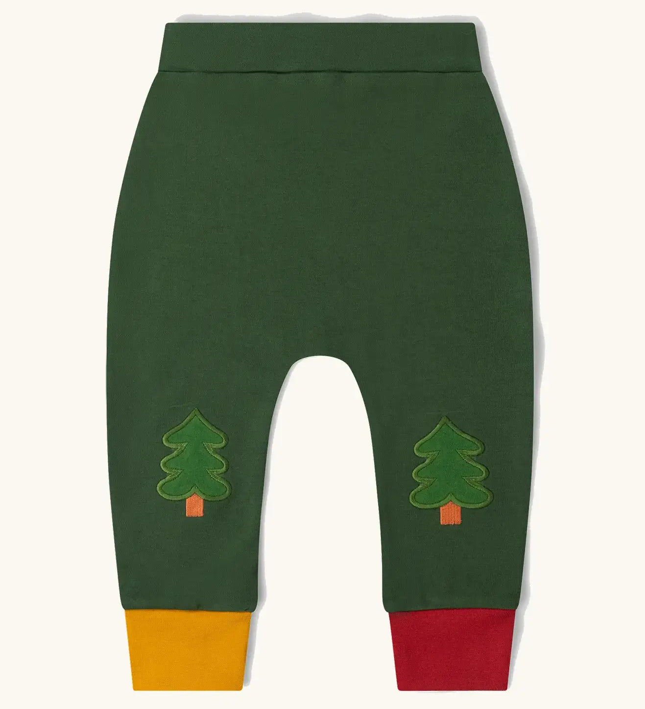 Little Green Radicals organic cotton woodland knee patch joggers. Dark green joggers with tree patches on the knee, one yellow and one red leg cuffs.