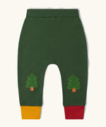 Little Green Radicals organic cotton woodland knee patch joggers. Dark green joggers with tree patches on the knee, one yellow and one red leg cuffs.
