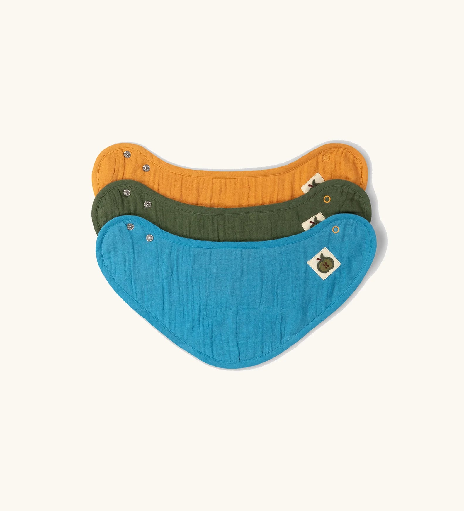 Little Green Radicals blue moon organic cotton muslin bandana bib set. Ochre yellow, dark green and teal blue bibs with green apple tag detail on one side.