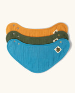 Little Green Radicals blue moon organic cotton muslin bandana bib set. Ochre yellow, dark green and teal blue bibs with green apple tag detail on one side.