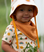 Child wearing the yellow ochre gold bandana style bib from the Little Green Radicals blue moon organic cotton muslin bib set.