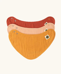 Little Green Radicals coral pink organic muslin bib set. Gold ochre yellow, red rust, and coral pink bandana style bibs in a pack of three.