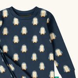 Close up of the Little Green Radicals penguins kids organic cotton pyjamas. Navy long sleeved pyjamas with all over repeat penguin print. 