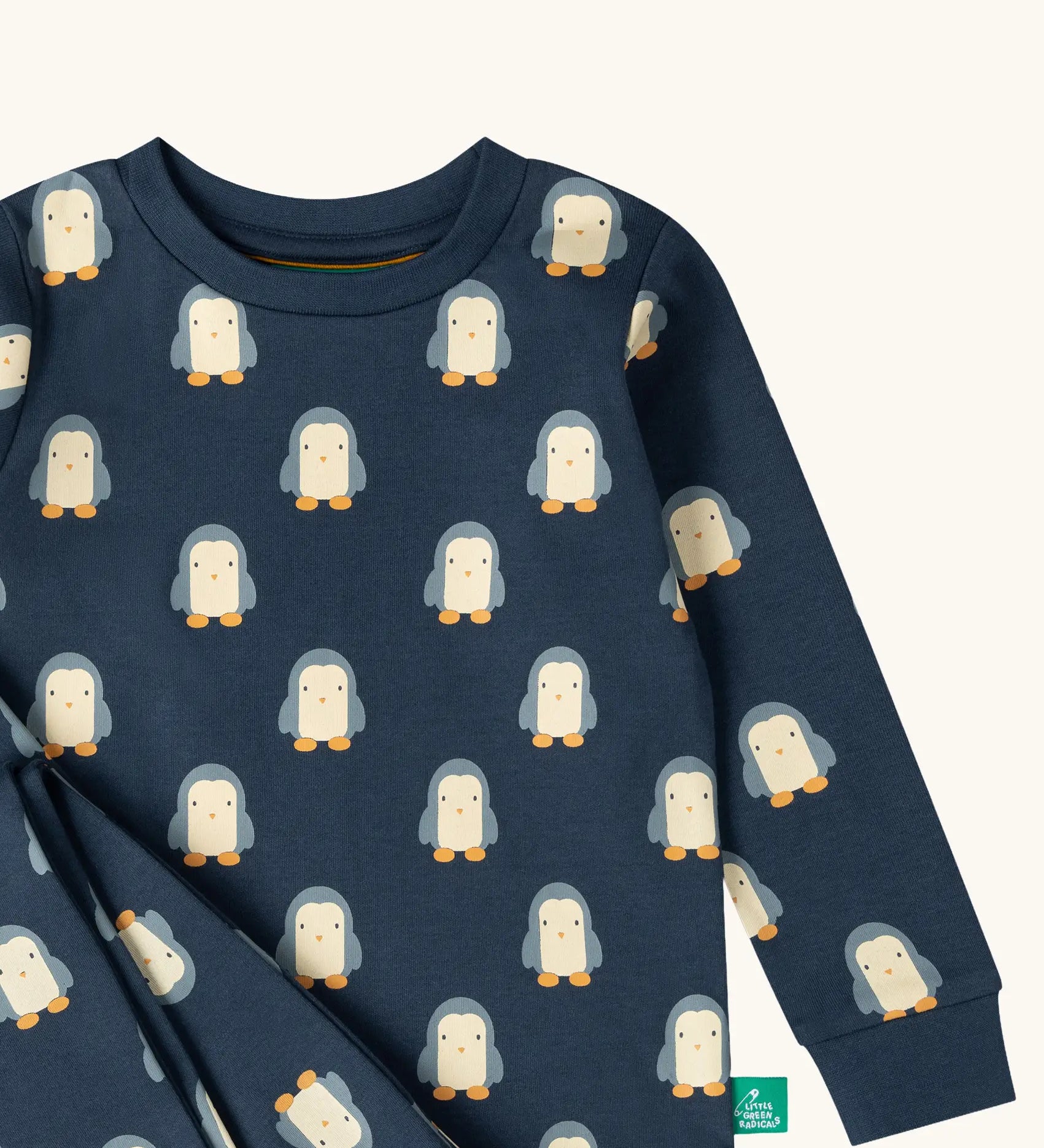 Close up of the Little Green Radicals penguins kids organic cotton pyjamas. Navy long sleeved pyjamas with all over repeat penguin print. 
