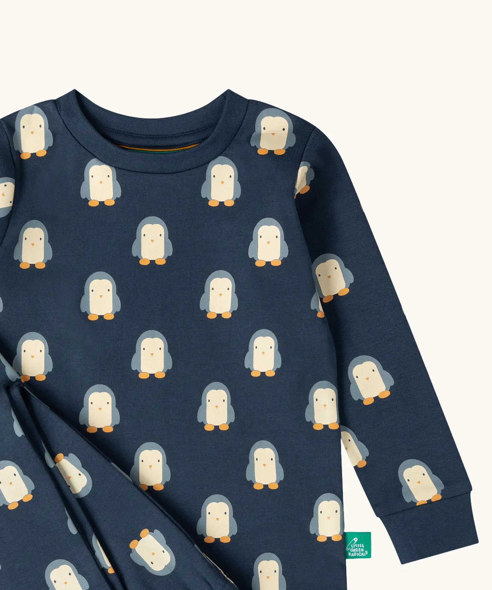 Close up of the Little Green Radicals penguins kids organic cotton pyjamas. Navy long sleeved pyjamas with all over repeat penguin print. 