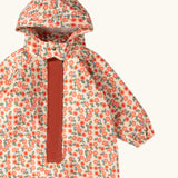 Close up of the Little Green Radicals petals recycled waterproof winter suit. Light background with pink repeat al over flower print. 