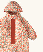 Close up of the Little Green Radicals petals recycled waterproof winter suit. Light background with pink repeat al over flower print. 
