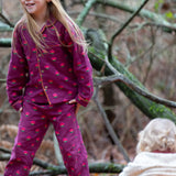 Child wearing the Little Green Radicals pink flowers organic cotton classic pyjamas.