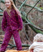 Child wearing the Little Green Radicals pink flowers organic cotton classic pyjamas.
