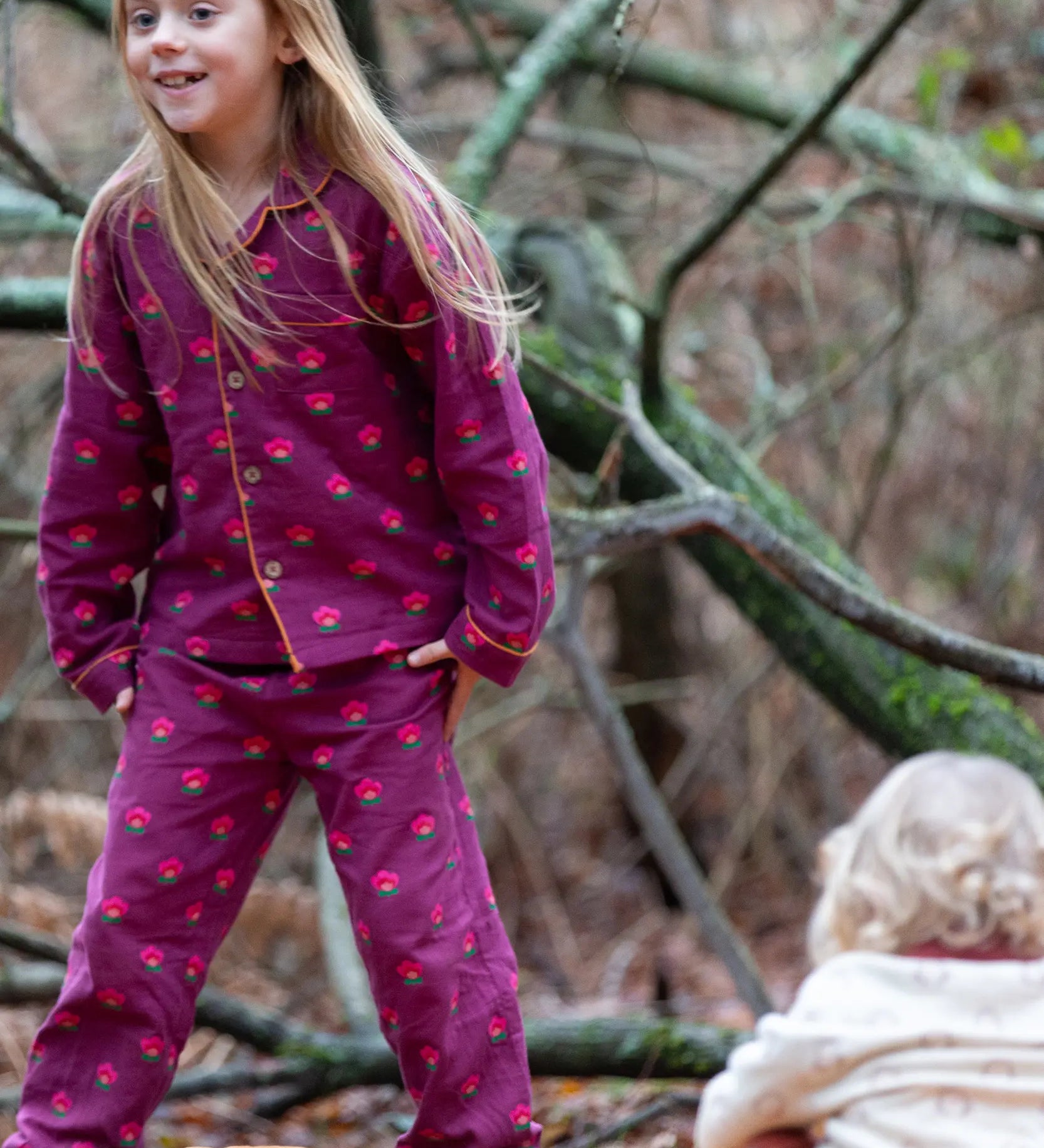 Child wearing the Little Green Radicals pink flowers organic cotton classic pyjamas.