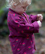Child wearing the Little Green Radicals pink flowers organic cotton classic pyjamas.