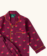 Close up of the Little Green Radicals pink flowers print organic cotton classic purple pyjamas. Long sleeve button up top with matching trousers.