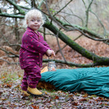 Child wearing the Little Green Radicals pink flowers organic cotton classic pyjamas with yellow gold wellingtons.