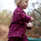 Side of a child wearing the Little Green Radicals pink flowers organic cotton classic pyjamas.
