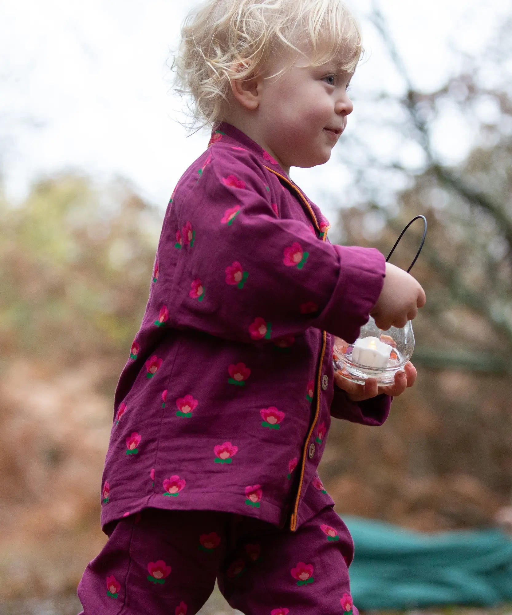 Side of a child wearing the Little Green Radicals pink flowers organic cotton classic pyjamas.